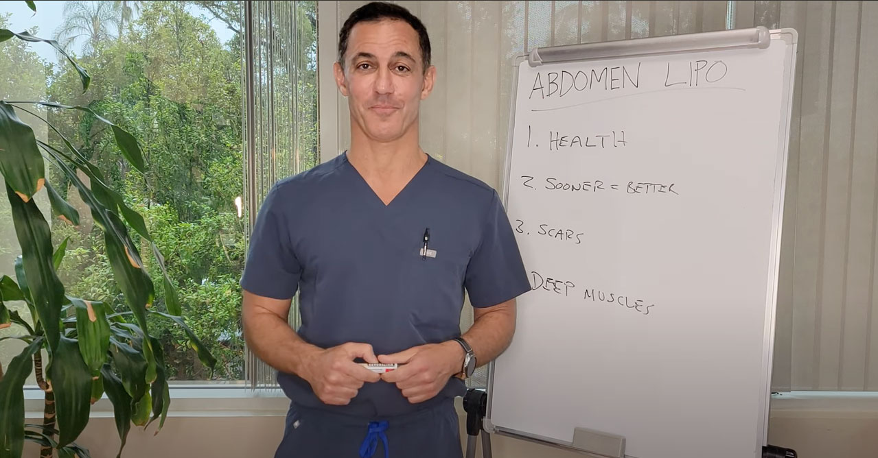 Man in scrubs standing in front of a whiteboard with notes